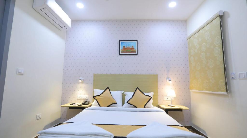 a bedroom with a large bed with two lamps at GRACE RESIDENCY in Chennai