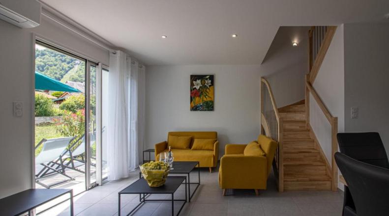 a living room with yellow furniture and a staircase at Gîte l'angélique Fleurs des Pyrénées in Argelès-Gazost