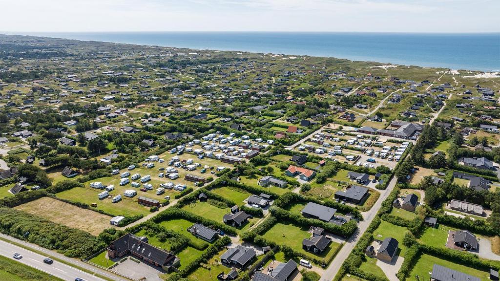 an aerial view of a suburb with houses and the ocean at Søndervig Camping & Cottages in Søndervig