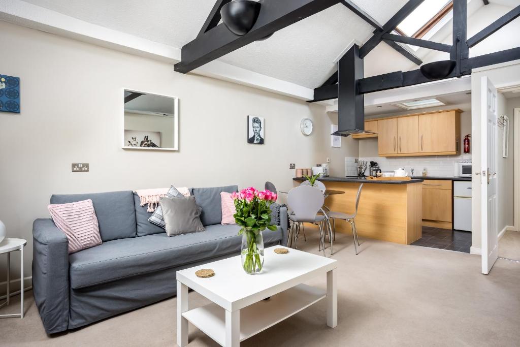 een woonkamer met een bank en een tafel bij Curb Properties - Super Apartment Moments From Town Centre in Cheltenham