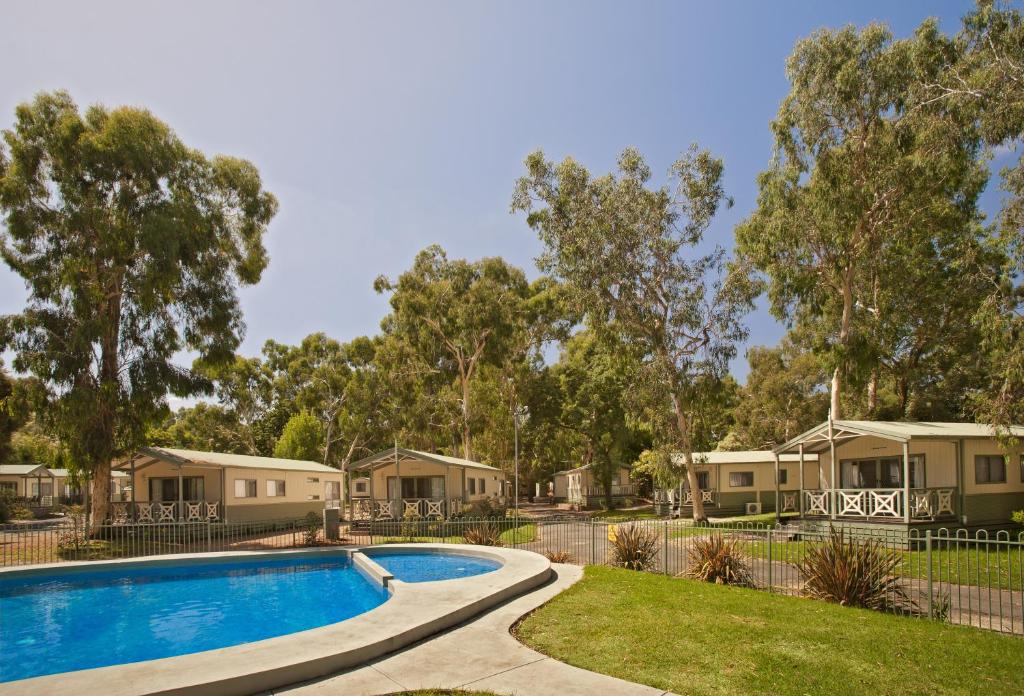 a hotel room with a pool and trees at Crystal Brook Tourist Park in Doncaster East