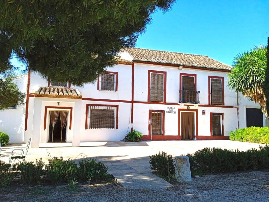 una casa blanca con persianas marrones y un árbol en Las maravillas de Manuel By Solymar Holiday, en Málaga