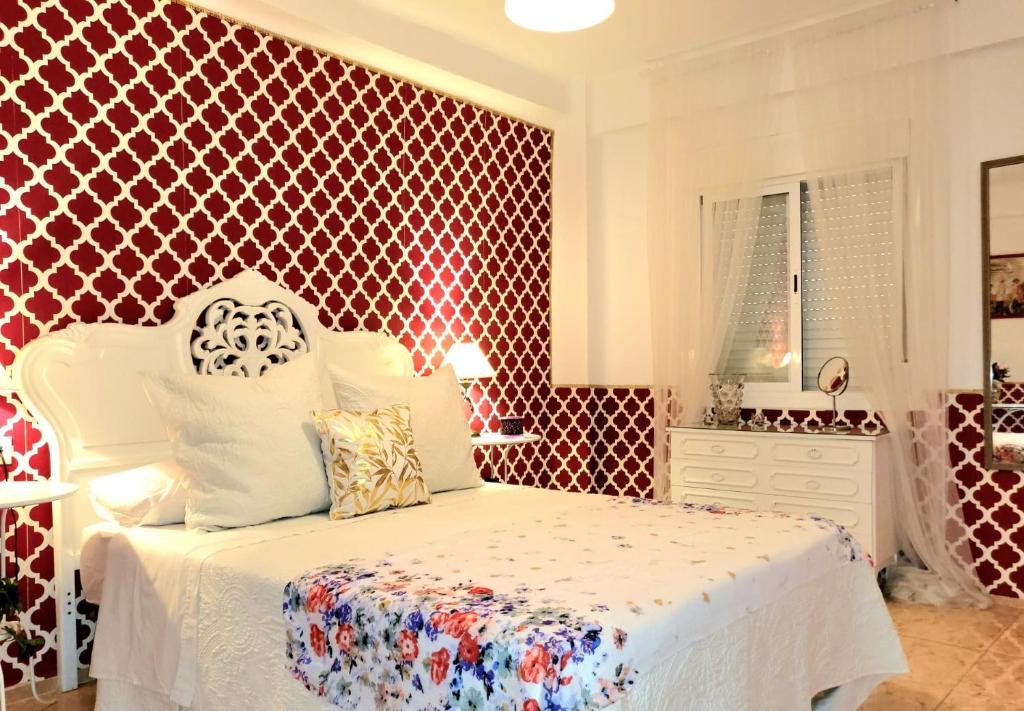 um quarto com uma cama branca e uma parede vermelha em Vintage apartment em Córdoba