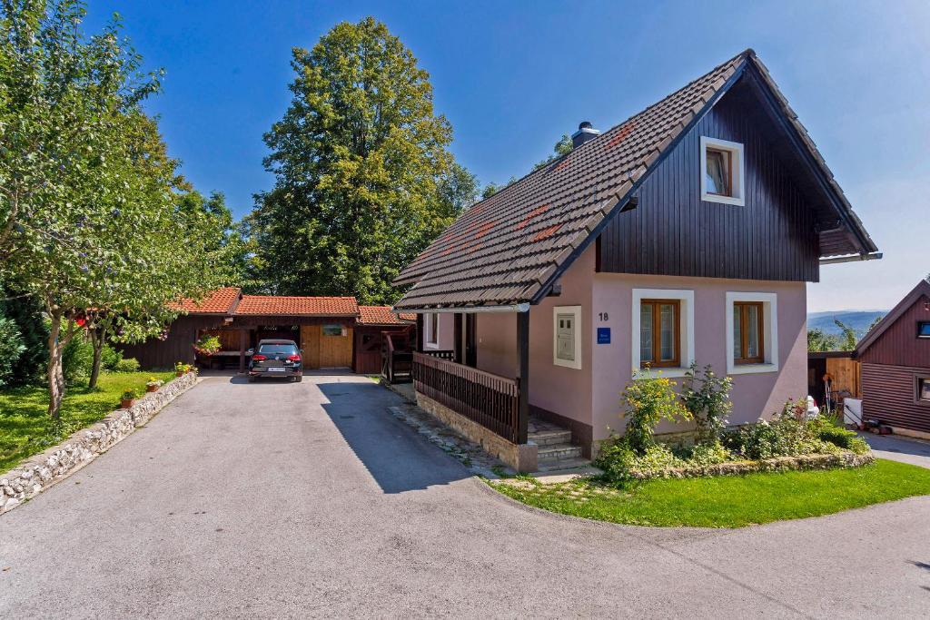 ein kleines Haus mit schwarzem Dach in der Unterkunft Andrea in Sertić Poljana - Haus für 6 Personen in Plitvička Jezera