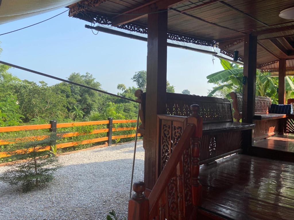 a porch of a house with a fence at Lampang Hideaway Guesthouse in Lampang