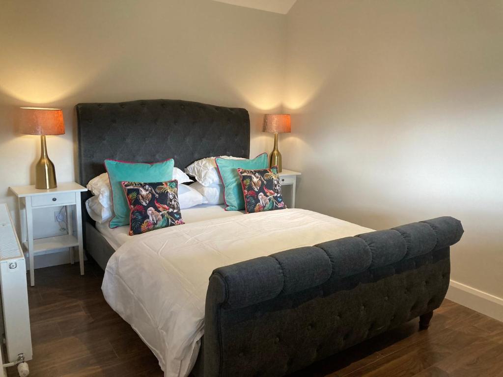 a bedroom with a large bed with a gray headboard at Clara Lodge in Sallins