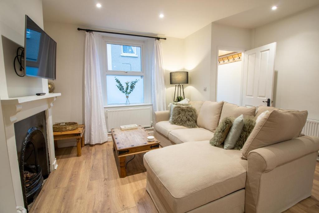 a living room with a couch and a fireplace at Stylish and Modern Town Centre End-of Terrace Home in Newton Abbot