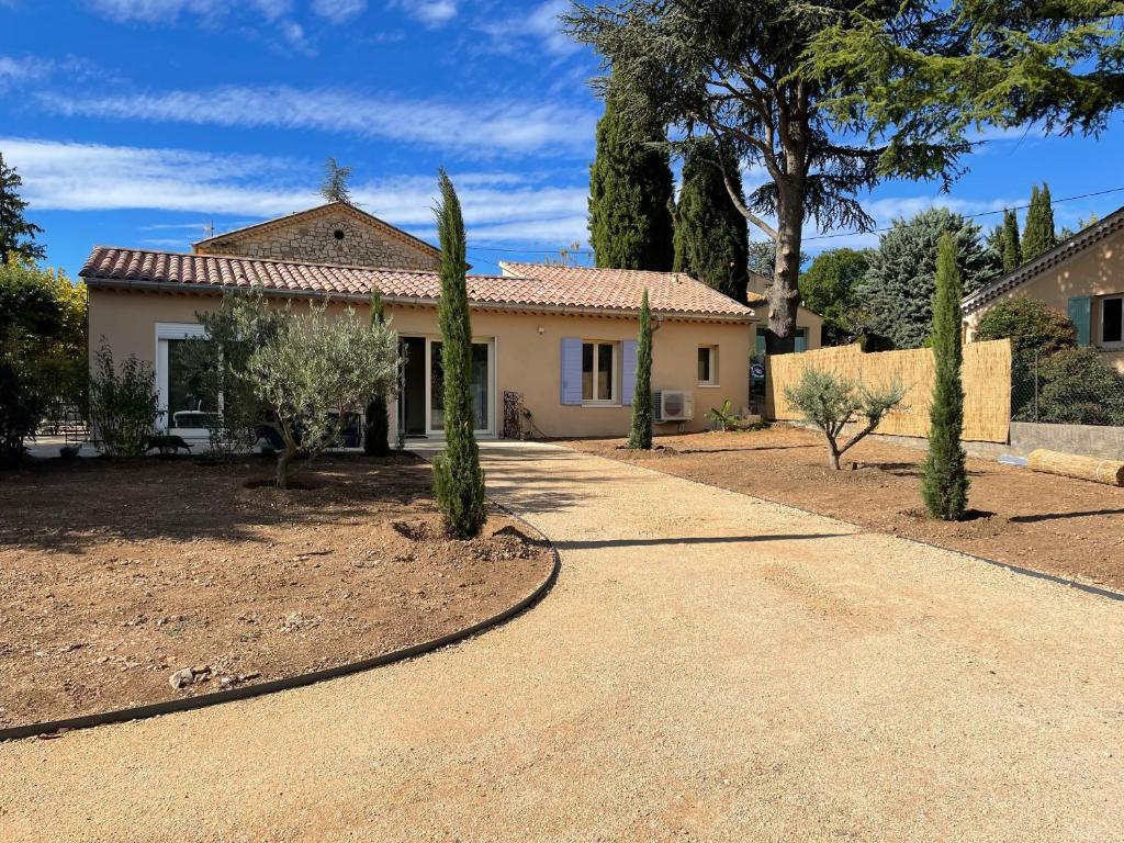a house with cypress trees in front of a driveway at lagalerie84 in Saint-Saturnin-dʼApt
