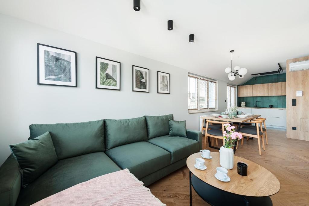 salon z zieloną kanapą i stołem w obiekcie Zen Apartment by LoftAffair w Krakowie