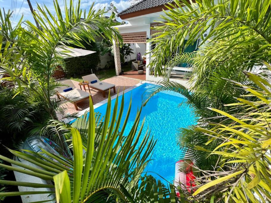 - une piscine dans une cour avec des palmiers dans l'établissement Holiday house near Lamai with swimming pool. 2 bedrooms, à Nathon Bay