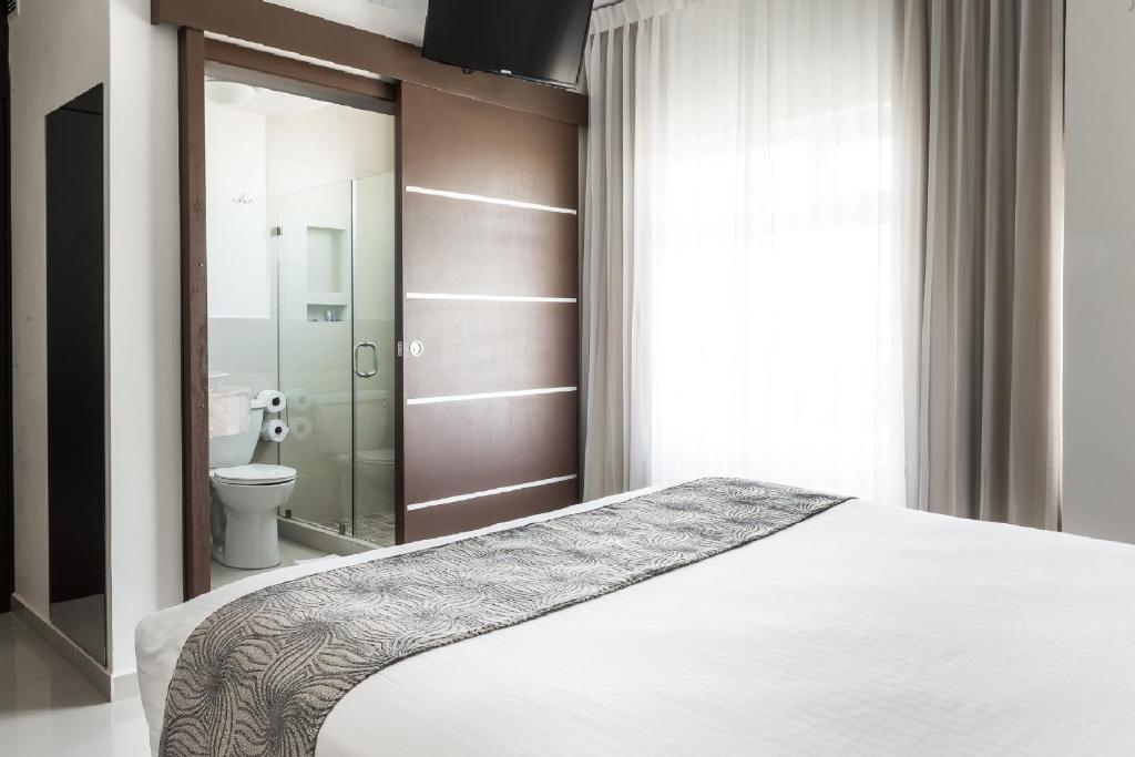 Postel nebo postele na pokoji v ubytování Hotel Latitud 15