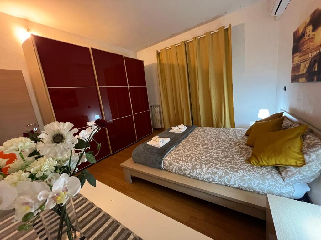 ein Schlafzimmer mit einem Bett und einer Vase aus Blumen in der Unterkunft Roma centro metro rebibbia in Rom