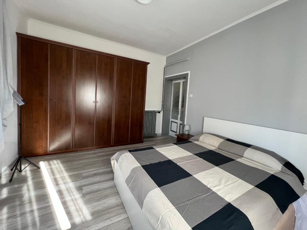 Schlafzimmer mit einem Bett und einem Holzschrank in der Unterkunft Il Ritrovo, luminoso trilocale in città in Bergamo