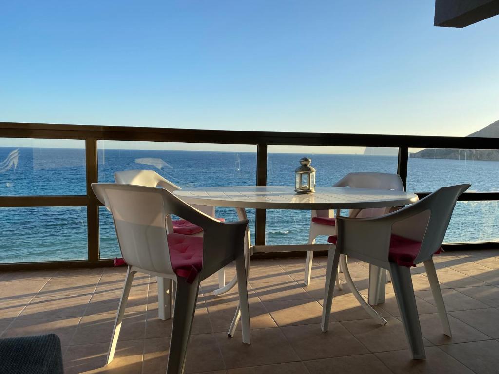 einen Tisch und Stühle auf einem Balkon mit Meerblick in der Unterkunft Calpe Mar y Playa in Ifach