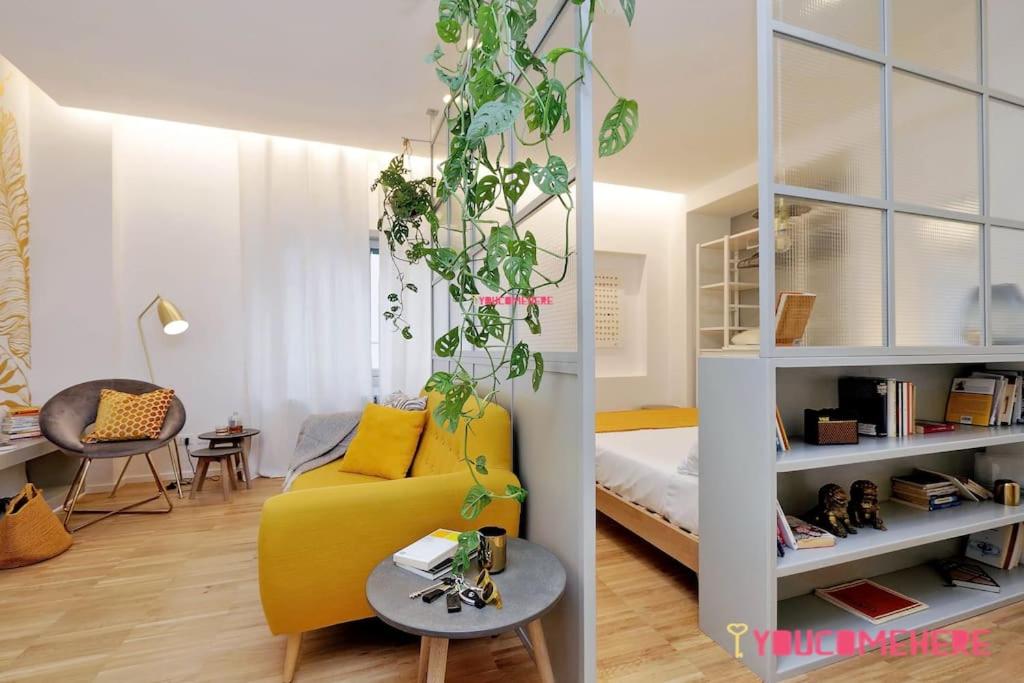 een woonkamer met een gele bank en een tafel bij RENOVATED AND DESIGN FLAT CLOSE TO THE CENTER in Rome