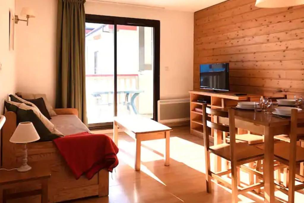 a living room with a couch and a table at CHARMANT T3 AVEC VUE SUR LA MONTAGNE in Font-Romeu-Odeillo-Via