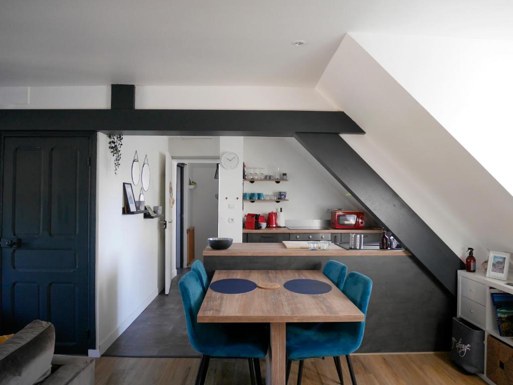 comedor con mesa y sillas azules en CLINT HOUSE - Appartement "Fou de Bassan" en Perros-Guirec