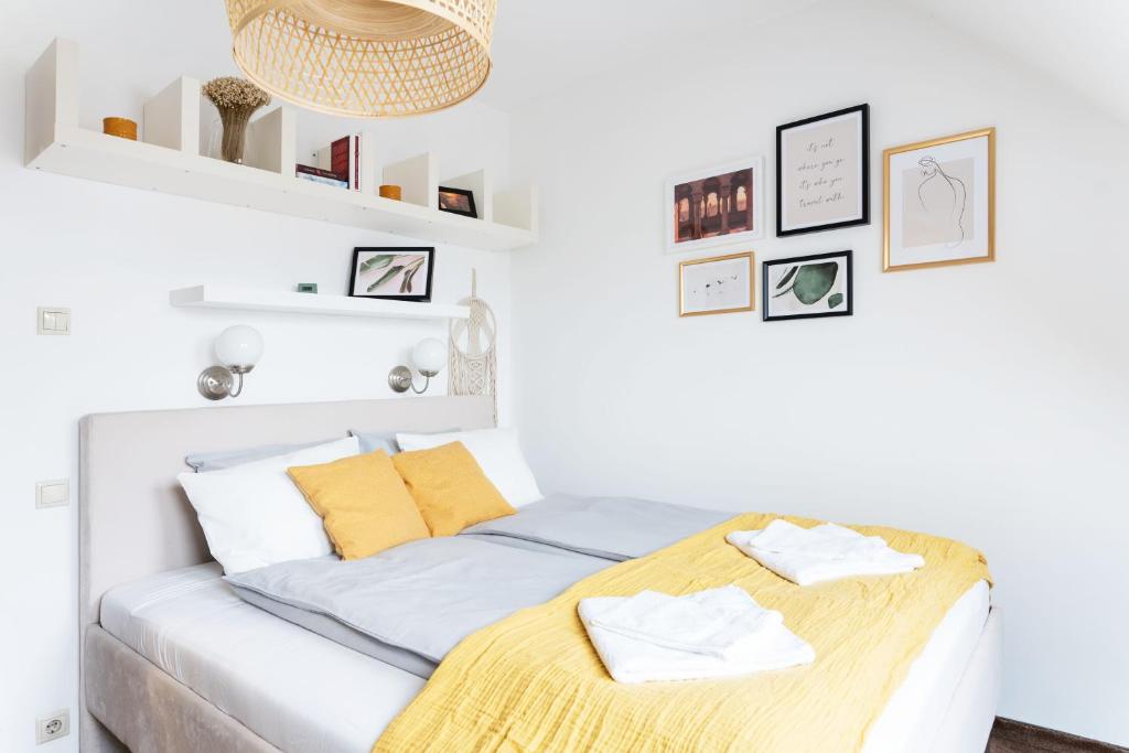 biała sypialnia z łóżkiem z żółtymi poduszkami w obiekcie Floral Apartment - NEW in town w Budapeszcie