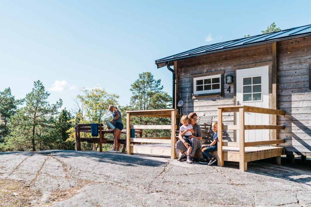 SöderbouddGistholmen的一群人坐在小屋外面