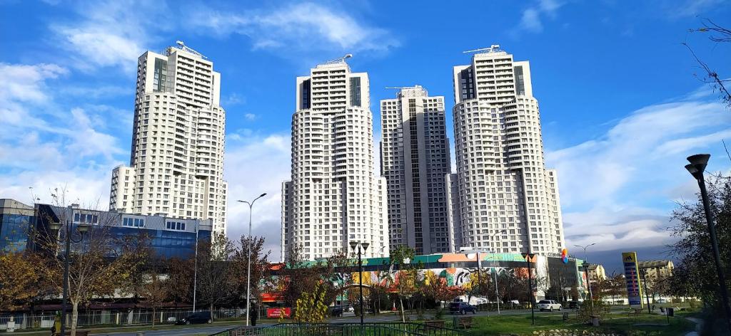 a group of tall white buildings in a city at 18th Floor Secure Luxury Condo With Pool & Fitness Included In Price in Skopje