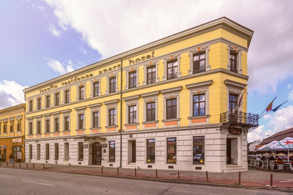 un bâtiment jaune sur le côté d'une rue dans l'établissement Hotel Iosefin Residence, à Timişoara
