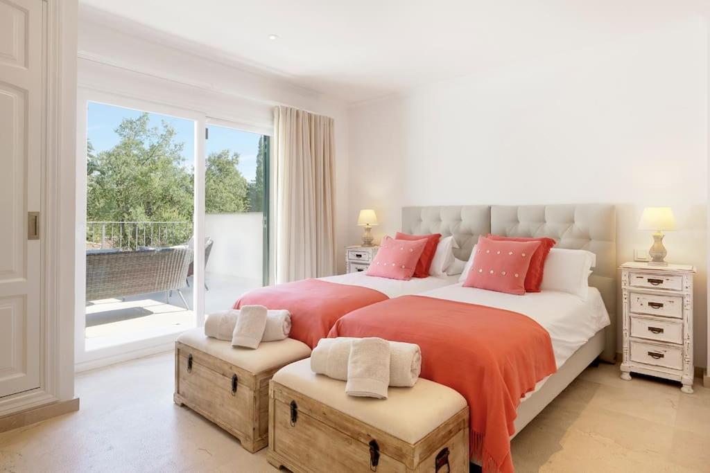 Habitación blanca con 2 camas y balcón. en Villa Esquina Luxury 5 Bed 5 Bath Pollensa en Pollença