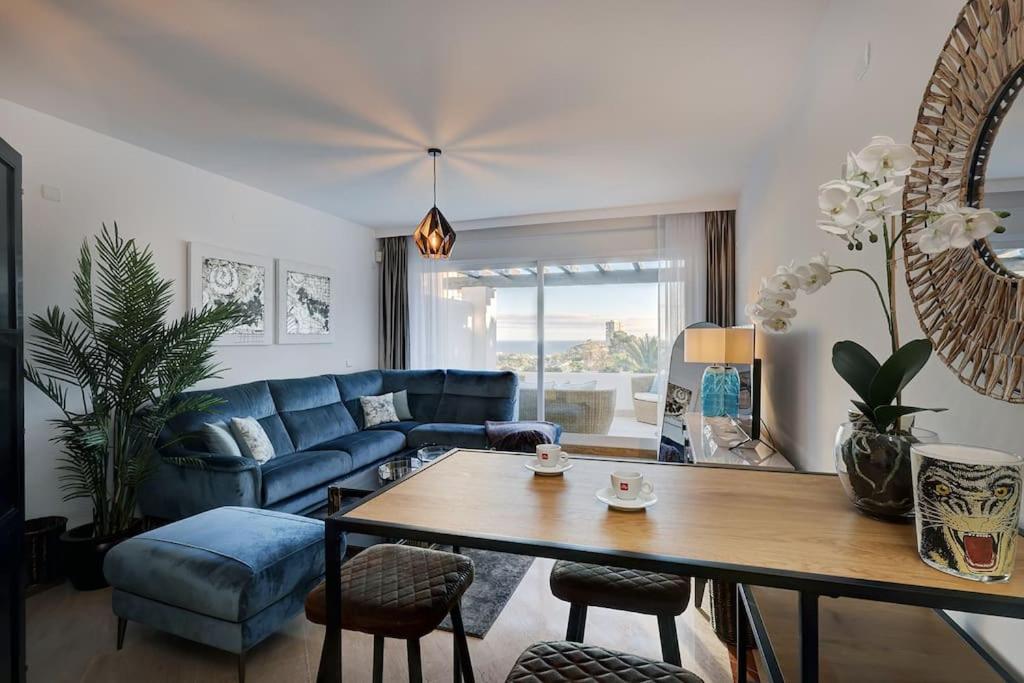 sala de estar con sofá azul y mesa en Luxurious 80m² studio apartment, stunning sea views - Rio Real Golf, Marbella, en Marbella