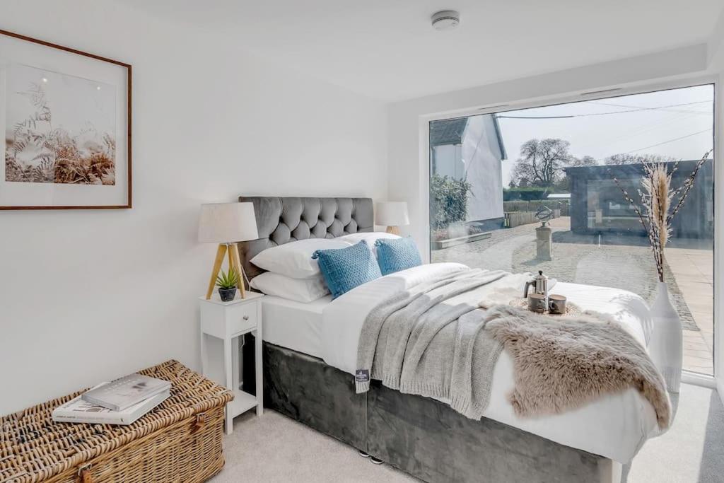 a bedroom with a large bed and a large window at Fen Lane Retreat in Norwich