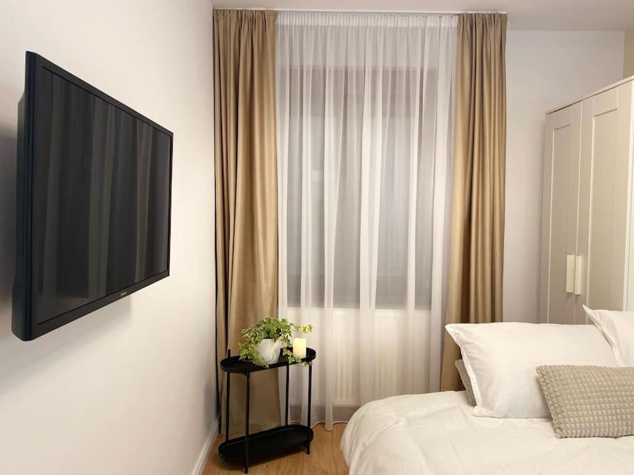 um quarto com uma cama e uma televisão de ecrã plano em Cloud House em Sibiu