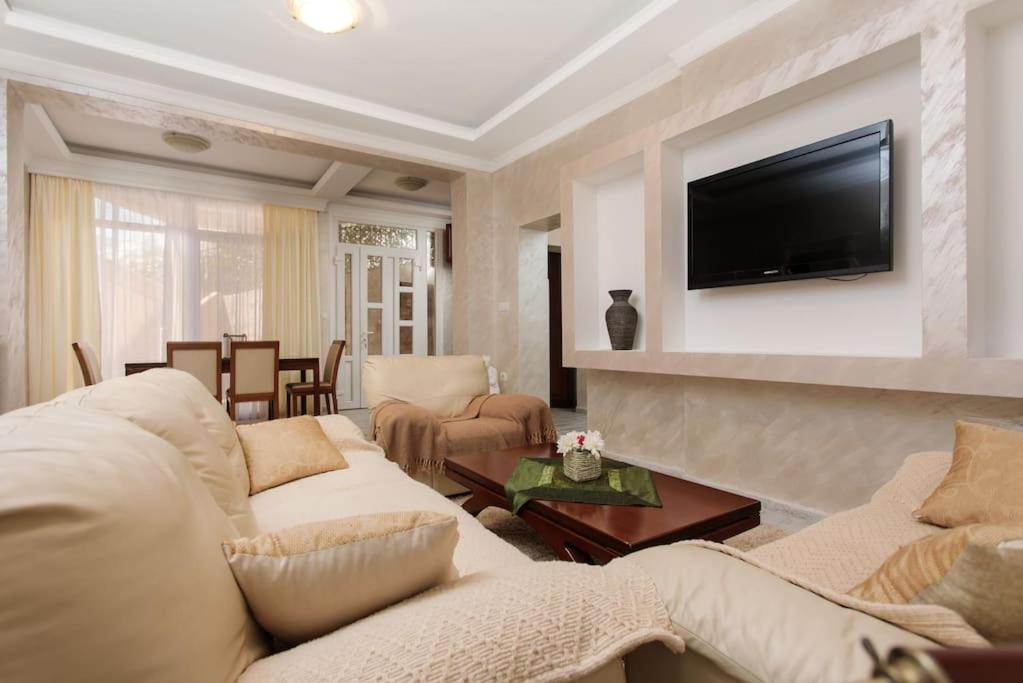 a living room with two white couches and a television at Summer retreat in Kotor