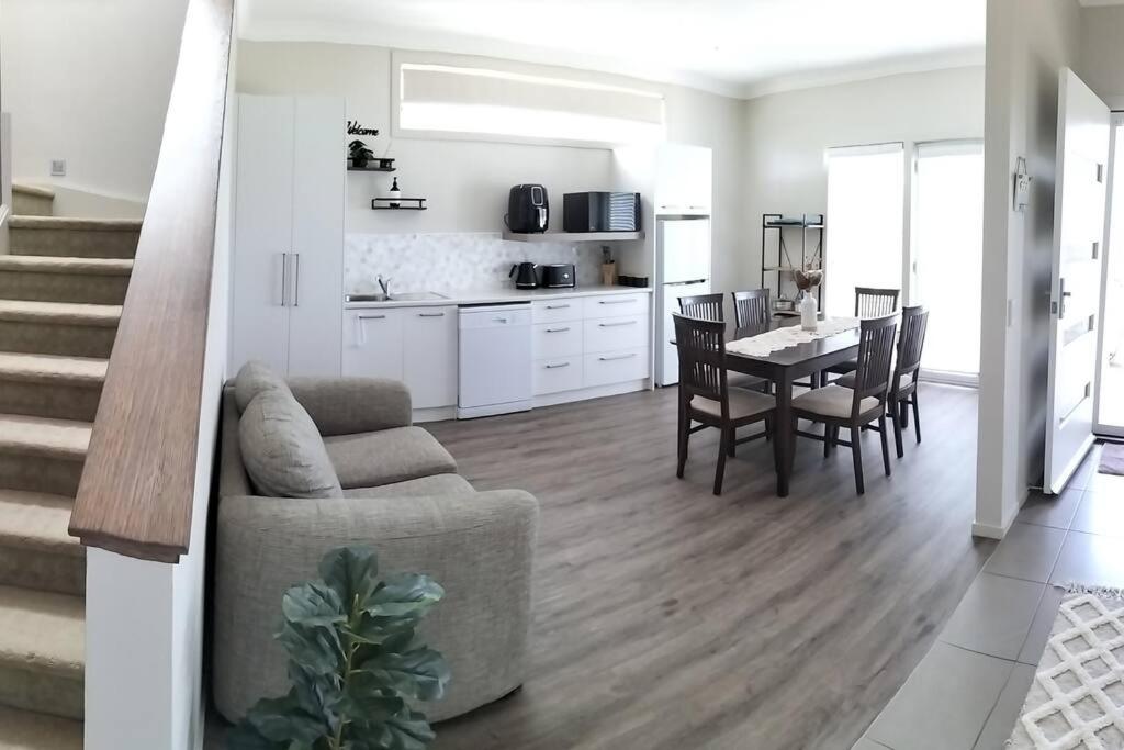 a living room and kitchen with a table and a couch at Surfmist Barrack Point in Barrack Point