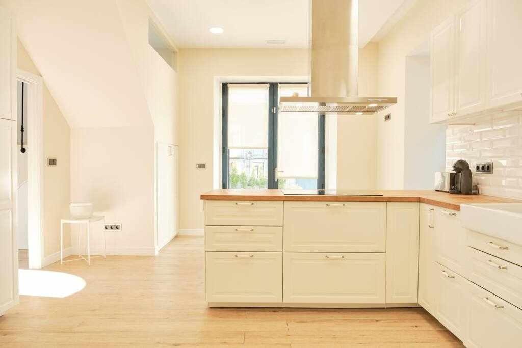 kuchnia z białymi szafkami i dużym oknem w obiekcie CASA ROLAO Elegante Casa Familiar 10 personas w mieście Sierra de Outes