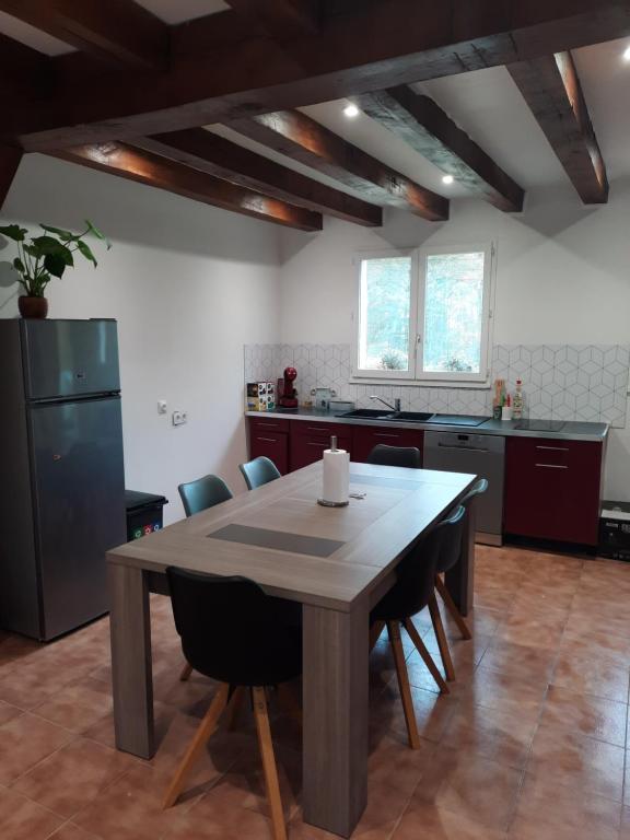 a large kitchen with a wooden table and chairs at maison de campagne au calme in Chuelles