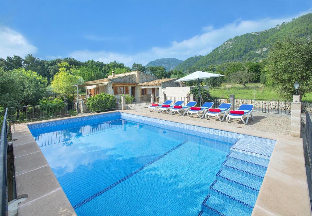 a swimming pool with chairs and a house at Owl Booking Villa Sedes - Dive Into Nature in Campanet