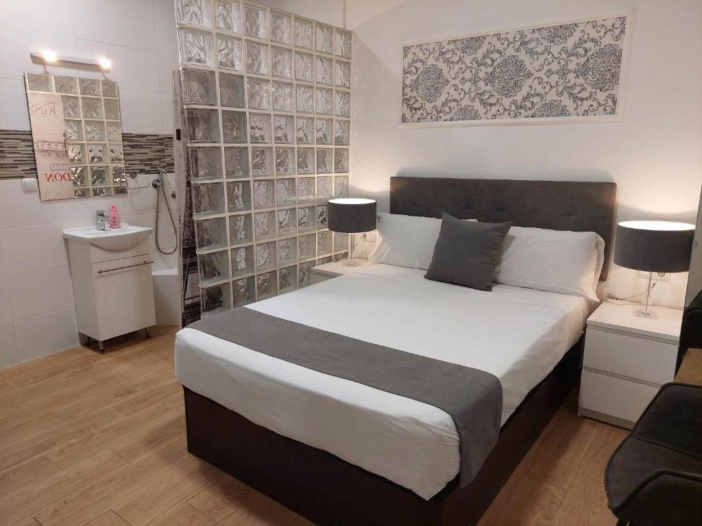 um quarto com uma grande cama branca num quarto em Apartamentos Rous - Solo adultos em Valência