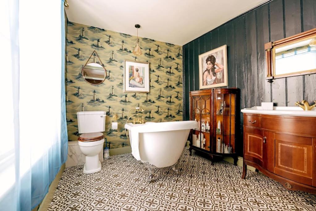 a bathroom with a tub and a toilet and a sink at The Wellie Stern a unique home recapturing history in Harwich