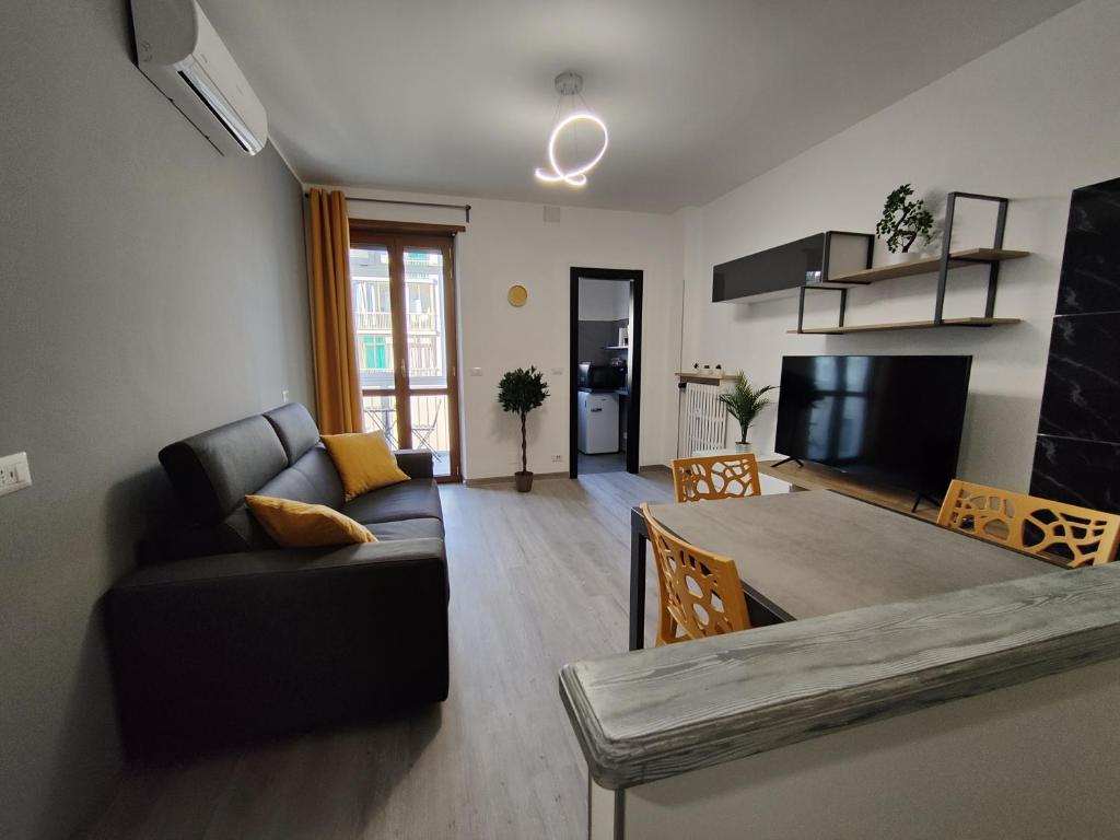 un soggiorno con divano, tavolo e TV di Santa Rita Suite a Torino