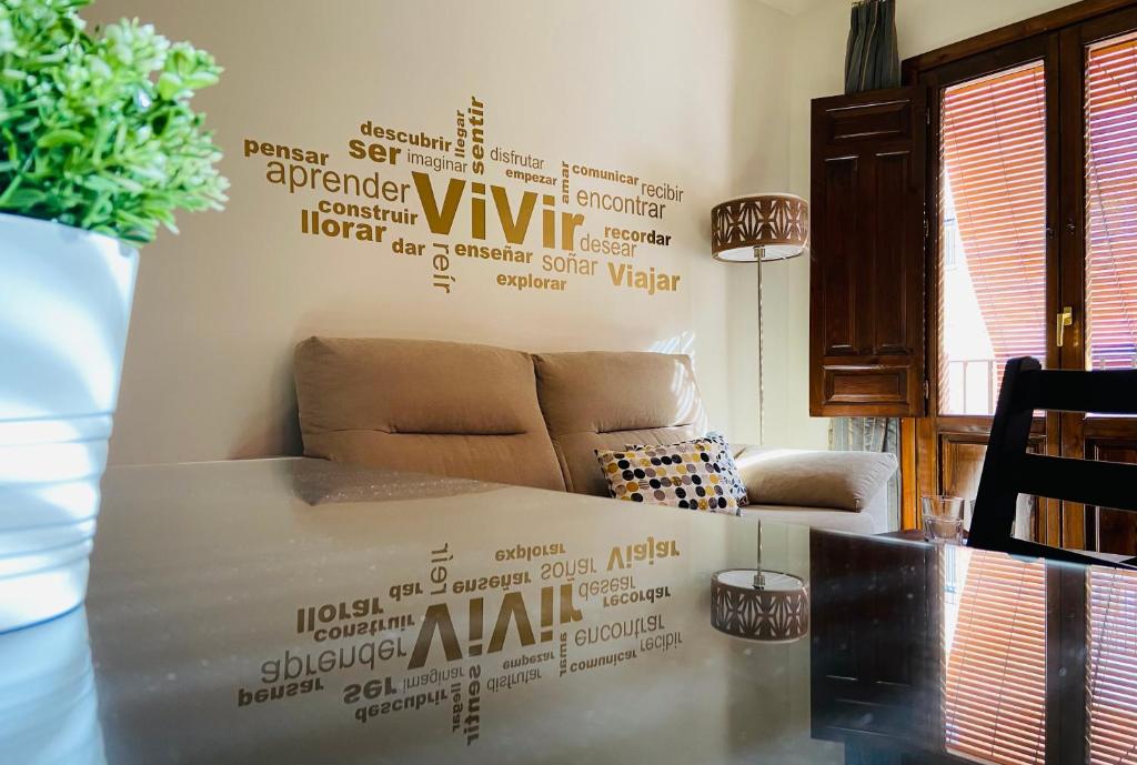 La Fonda del Arco في غواديكس: غرفة معيشة مع أريكة وجدار مغطى بالصناديق