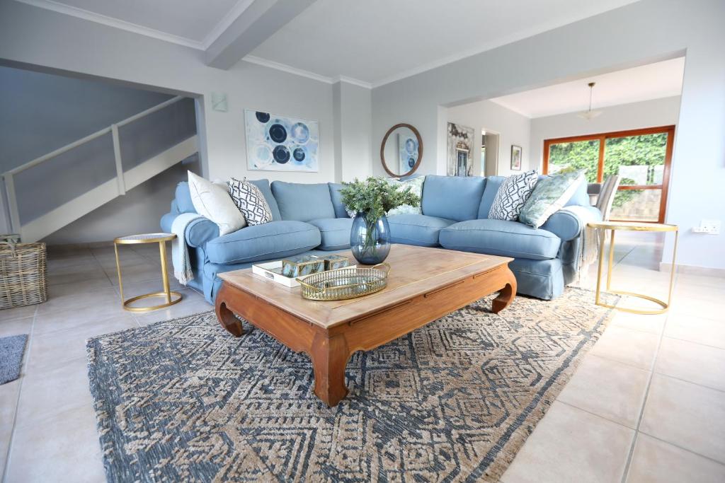 a living room with blue couches and a coffee table at Above & Beyond Houtbay in Hout Bay