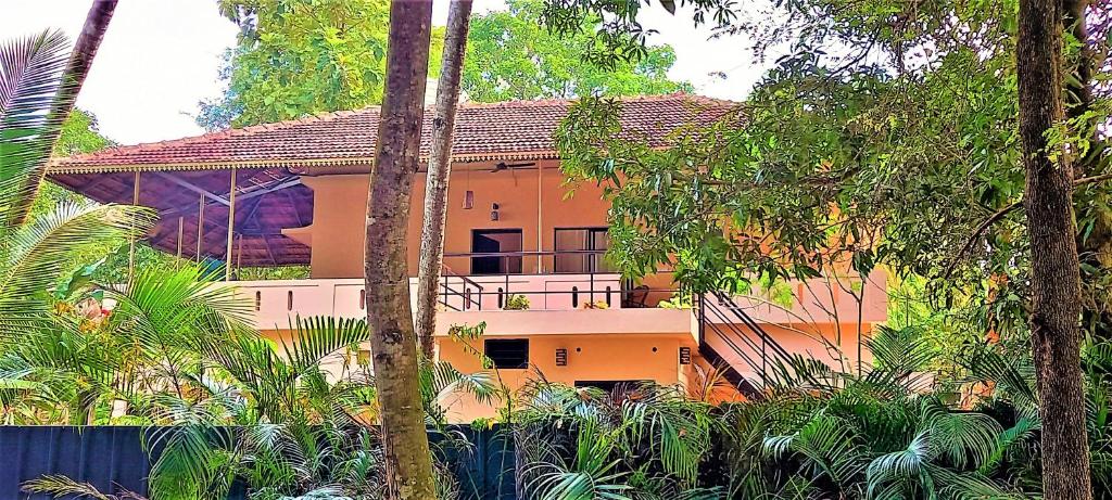 een huis met een balkon midden tussen de bomen bij Bella Beach Villa in Mararikulam