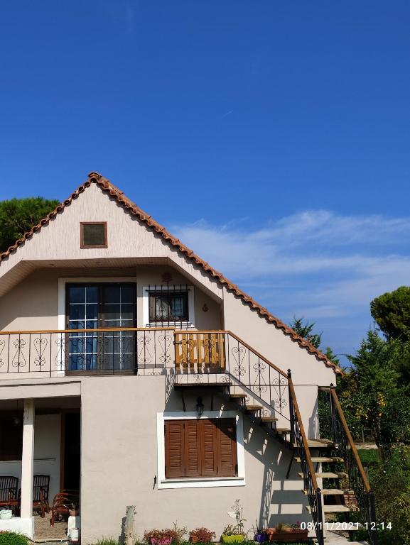 uma casa com uma escada e uma varanda em Σοφίτα Μαρτά em Kalamos