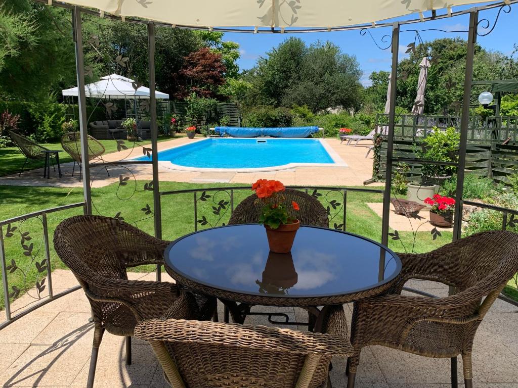 a table and chairs on a patio with a pool at La Sellerie at No 17 in Le Dorat