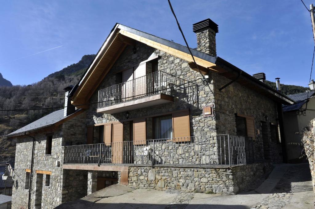 a stone house with a balcony on the side of it at Casa Franch in Espot