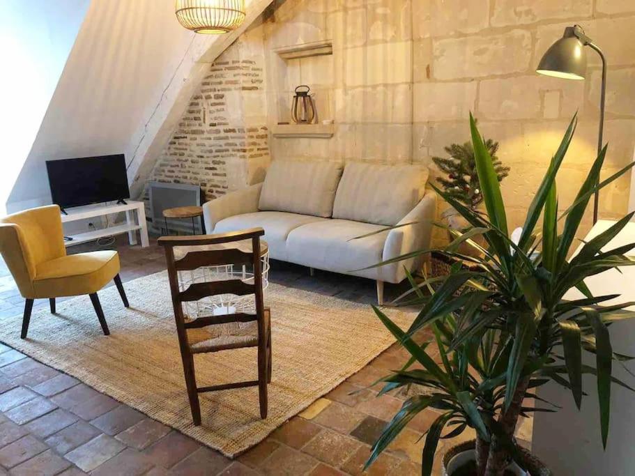 a living room with a couch and a chair at La Scellerie, le charme au cœur de Tours in Tours