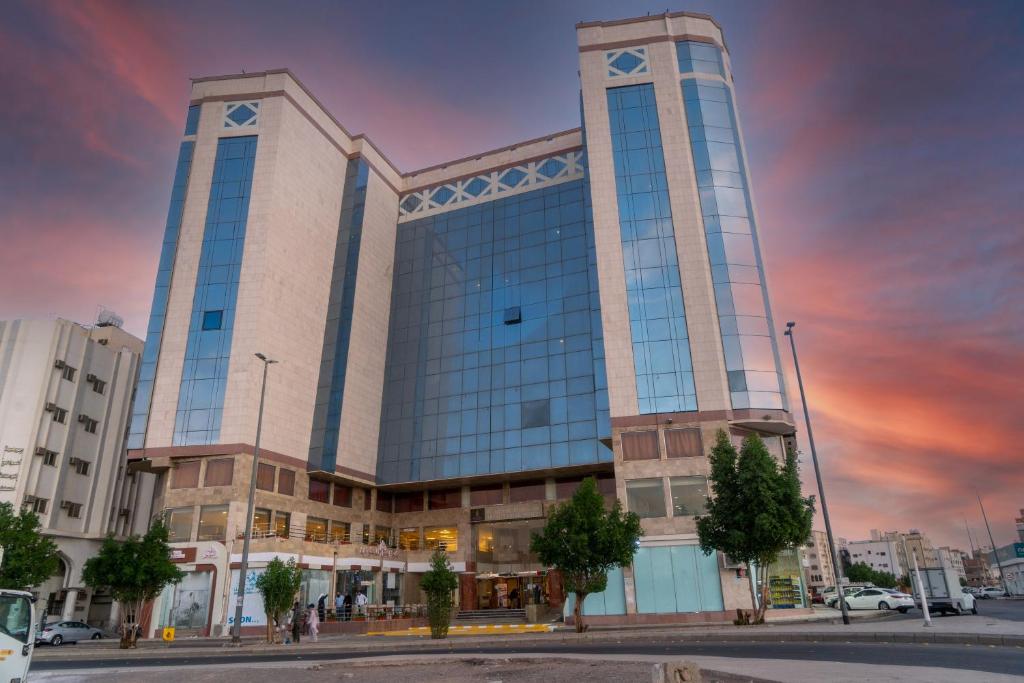 ein hohes Gebäude mit Sonnenuntergang im Hintergrund in der Unterkunft Artal Taiba Hotel in Medina