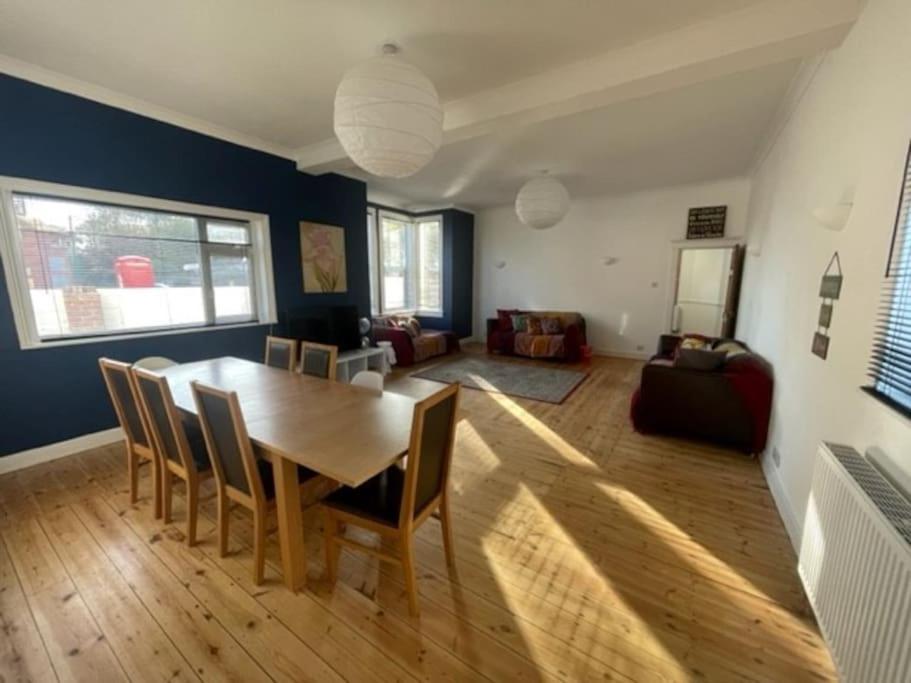 a living room with a wooden table and chairs at Blue Sky Lodge in Overstrand