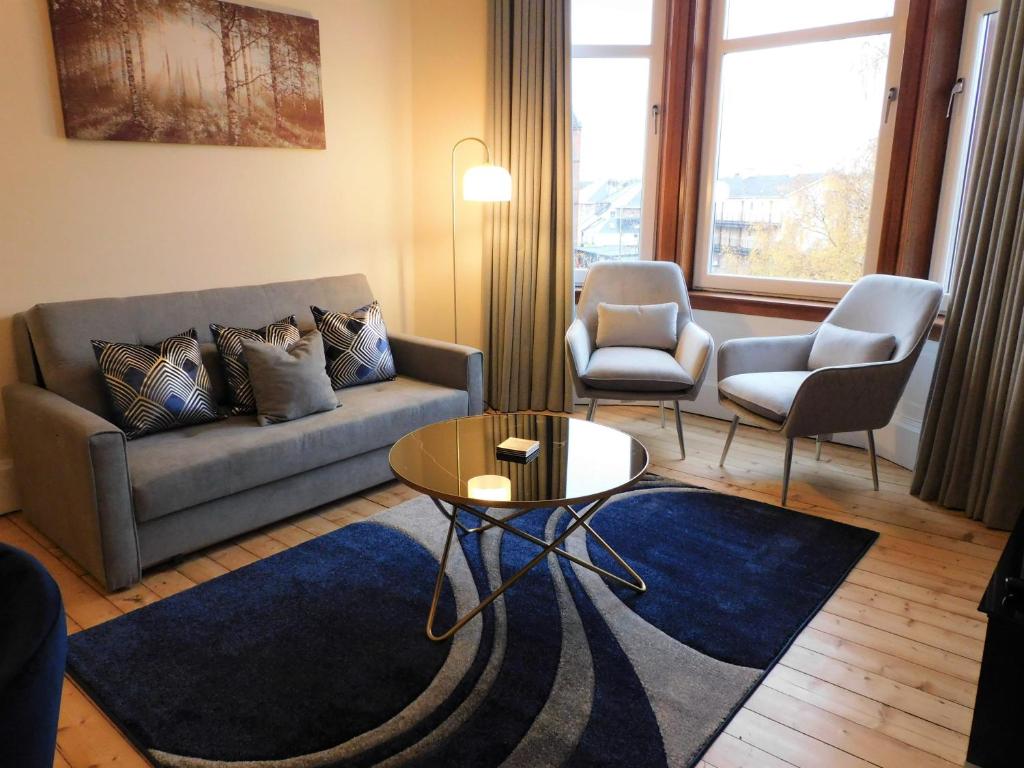 ein Wohnzimmer mit einem Sofa, einem Tisch und Stühlen in der Unterkunft Beautiful & spacious 2 bed apt in Glasgow West End in Glasgow