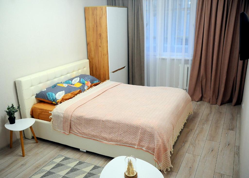 ein kleines Schlafzimmer mit einem Bett und einem Fenster in der Unterkunft BoHo Apartment near Center! in Chişinău