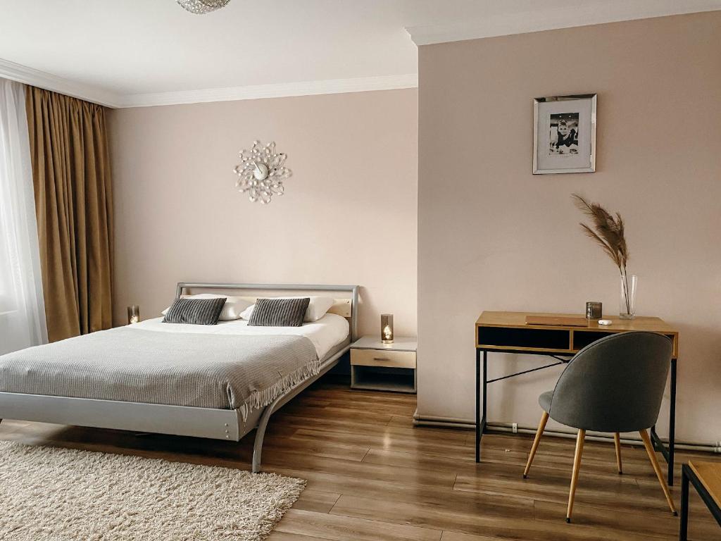 - une chambre avec un lit, un bureau et une chaise dans l'établissement Апартаменти в центрі Тернополя, à Ternopil