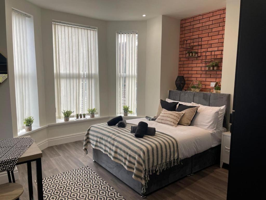 um quarto com uma cama grande e uma parede de tijolos em Deluxe Centrally Located Studio Apt in Manchester em Manchester